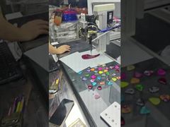 This automatic sticker dispensing machine combines sticker attachment and glue dispensing processes.